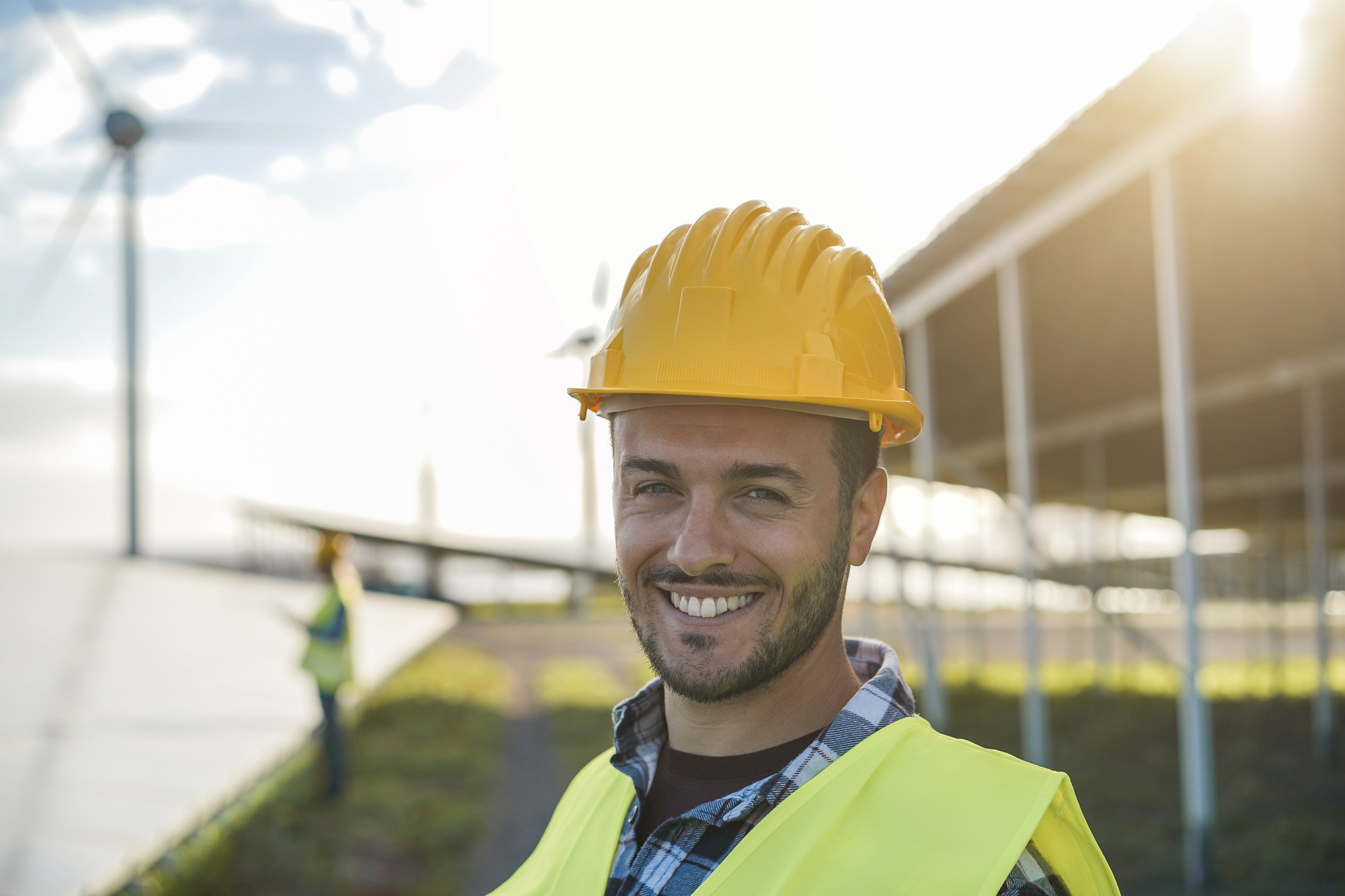 Young man working at renewable energy farm - Eco and enviroment concept - Focus on face Young man working at renewable energy farm - Eco and enviroment concept - Focus on face